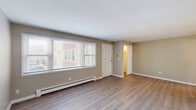 Located in Chicago's O'Hare neighborhood, this 2-bedroom, 1-bathroom unit offers a well-organized single-floor layout designed for comfortable everyday living. Light-toned, hardwood-style flooring runs throughout, complementing the neutral warm-gray walls and crisp white trim found in every room.

The living room is a welcoming, open space featuring a large picture window that draws in generous natural light and offers views of the surrounding neighborhood. A baseboard heating system runs along the perimeter, and the clean, uncluttered layout provides flexible furniture arrangements.

The kitchen is efficiently designed with taupe cabinetry, subway tile backsplash, and a full suite of stainless steel appliances including a gas range, built-in microwave, and dishwasher. A ceiling fan overhead adds comfort and airflow.

Both bedrooms are well-proportioned, with the primary bedroom offering a notably spacious footprint and its own closet. The second bedroom features corner windows that invite natural light from two directions. Three closets throughout the unit provide ample storage.

The bathroom is finished with classic white subway tile surrounding a full soaking tub and shower, accented by a glass block window that allows light while maintaining privacy. A connecting hallway ties all rooms together in a logical, easy-to-navigate flow.