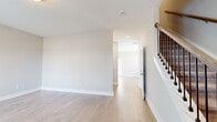 Located at 2501 Hanford Ave in Nashville, TN, this two-story home offers three bedrooms and three bathrooms across two well-proportioned floors. The main level features an open-concept kitchen and living area with light hardwood flooring that flows throughout. The kitchen is a standout, boasting crisp white shaker cabinets, dark granite countertops, stainless steel appliances including a refrigerator, range, microwave, and dishwasher, along with a large island with pendant lighting — ideal for cooking and entertaining. A convenient half bathroom with wood-look flooring and a pedestal sink is also located on the main level, alongside a dedicated laundry room with full-size washer and dryer hookups. Upstairs, the primary bedroom is a generously sized retreat with plush carpeting, natural light from large windows, and direct access to a private en-suite bathroom. Two additional carpeted bedrooms share access to a full bathroom featuring tile surround, a soaking tub, and a granite-topped vanity. A wood-railed staircase connects both levels, complementing the home's clean, modern aesthetic defined by neutral tones, bright interiors, and thoughtful finishes throughout.