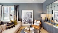 Located in Indian Trail, NC, this thoughtfully designed single-floor residence offers a cohesive blend of modern finishes and contemporary style. The open-concept kitchen serves as a functional centerpiece, featuring stainless steel appliances, a large granite-topped island with bar seating, two-tone cabinetry with white upper cabinets and gray lower cabinets, a subway tile backsplash, and durable wood-look flooring. The living area exudes a sophisticated ambiance with deep charcoal-gray accent walls, natural light streaming through large windows, and views of the surrounding greenery.

The primary bedroom is a serene retreat with a ceiling fan, plush carpeting, and ample natural light. Its en-suite bathroom is equipped with a double-sink vanity topped with granite counters, gray cabinetry, and a glass-enclosed walk-in shower with white subway tile. A secondary bedroom mirrors the stylish design with two-tone gray wainscoting and generous window exposure. The secondary bathroom continues the clean aesthetic with subway tile, a soaking tub, and a single vanity with granite countertops. Throughout the space, consistent use of black hardware accents and warm wood-look flooring ties each room together with modern, intentional design.