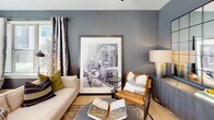 Located in Indian Trail, NC, this thoughtfully designed single-floor residence offers a cohesive blend of modern finishes and contemporary style. The open-concept kitchen serves as a functional centerpiece, featuring stainless steel appliances, a large granite-topped island with bar seating, two-tone cabinetry with white upper cabinets and gray lower cabinets, a subway tile backsplash, and durable wood-look flooring. The living area exudes a sophisticated ambiance with deep charcoal-gray accent walls, natural light streaming through large windows, and views of the surrounding greenery.

The primary bedroom is a serene retreat with a ceiling fan, plush carpeting, and ample natural light. Its en-suite bathroom is equipped with a double-sink vanity topped with granite counters, gray cabinetry, and a glass-enclosed walk-in shower with white subway tile. A secondary bedroom mirrors the stylish design with two-tone gray wainscoting and generous window exposure. The secondary bathroom continues the clean aesthetic with subway tile, a soaking tub, and a single vanity with granite countertops. Throughout the space, consistent use of black hardware accents and warm wood-look flooring ties each room together with modern, intentional design.