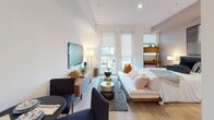 Located along the iconic Wilshire Boulevard in Los Angeles, this modern single-floor studio offers a thoughtfully designed open-concept layout that maximizes every inch of space. Light hardwood flooring runs throughout, lending warmth and continuity to the interior.

The kitchen is outfitted with sleek white cabinetry extending to the ceiling, quartz countertops, a white subway tile backsplash, and a full suite of stainless steel appliances including an electric range, over-the-range microwave, and refrigerator. The design is clean and functional, flowing seamlessly into the combined living and sleeping area.

The living space is bright and airy, benefiting from large floor-to-ceiling windows that invite generous natural light and offer views of the surrounding cityscape. The open layout comfortably accommodates a seating area and sleeping quarters side by side, creating a versatile and efficient use of space.

The bathroom features large-format stone-look porcelain tile on both the floors and shower surround, paired with a soaking tub and crisp white fixtures, creating a calm, spa-like atmosphere.

Clean white walls, recessed lighting, and a contemporary aesthetic throughout give this unit a polished, modern character well-suited to urban living in one of Los Angeles' most central and well-connected neighborhoods.