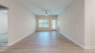 Located at 150 E Forest Park Dr in Dickson, Tennessee, this well-appointed 2-bedroom, 2-bathroom single-story home offers a thoughtfully designed layout with modern finishes throughout. The open living room is bright and welcoming, featuring light wood-look flooring, a ceiling fan, large windows with blinds, and a glass door leading to a private balcony that overlooks a lush, tree-lined landscape. The kitchen is equipped with crisp white shaker-style cabinetry, a subway tile backsplash, dark granite countertops, and stainless steel appliances including a range and over-the-range microwave. Both bedrooms are carpeted and receive natural light through windowed walls with blinds, providing a comfortable and quiet retreat. The primary bedroom includes a walk-in closet with wire shelving. The bathrooms feature light wood-look tile flooring, white vanities with dark granite countertops, and a tub-shower combination with white subway tile surround. A dedicated laundry room includes a washer and dryer and additional wire shelving for storage. Neutral tones and consistent finishes create a clean, cohesive aesthetic throughout the home.