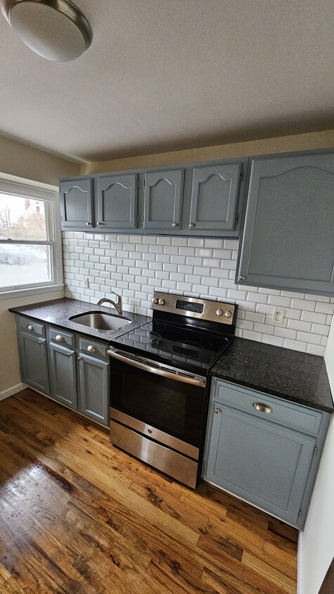 Kitchen with granite countertops and stainless steel appliances - 61 E Main St