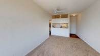 Located at 8503 Tobias Ave in the Panorama City neighborhood of Los Angeles, this single-floor unit offers a functional and comfortable layout. The living area is spacious and bright, featuring neutral beige carpeting, crisp white walls, and a textured ceiling. A ceiling fan provides year-round comfort, while a pass-through counter connects the living space to the kitchen, creating an open, communicative flow between the two areas. The kitchen features white cabinetry and overhead lighting, keeping the space clean and practical.

The bedroom is generously sized, filled with natural light streaming through a large window dressed with vertical blinds that offer views of surrounding greenery. Beige carpet continues throughout, and a wall-mounted HVAC unit ensures climate control. The room's clean, white walls provide a neutral canvas adaptable to any style.

The bathroom includes a vanity with a light countertop, a large wall mirror, and a shower-tub combination fitted with a decorative curtain. Wood-look flooring adds warmth to this functional space.

Throughout the unit, the design is clean and straightforward, with an emphasis on brightness and practicality — well-suited for comfortable everyday living in Los Angeles.