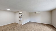 This two-bedroom, one-bathroom residence in Milford, Connecticut offers a practical and well-organized single-floor layout. The living room is a spacious, carpeted area bathed in natural light from large windows, featuring a wall-mounted mini-split air conditioning unit for year-round comfort and a textured ceiling throughout. An open sightline connects the living area directly to the kitchen, which is outfitted with white shaker-style cabinetry, dark granite-look countertops, tile flooring, and a full suite of white appliances including a range, built-in microwave, dishwasher, and refrigerator. A window above the sink brings in additional natural light.

The primary bedroom is a generously sized, sun-filled room with plush carpeting, a wide triple-panel window, a wall-mounted mini-split unit, and an expansive built-in closet with bi-fold doors. The second bedroom is equally comfortable, with soft carpet and ample natural light. The bathroom features neutral stone-look tile flooring, white subway tile surrounds, a window for ventilation, a baseboard heater, and a safety grab bar. Two closets and a connecting hallway complete the efficient floor plan, making this a well-appointed and functional residence.