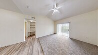 Located on Wurzbach Road in San Antonio, Texas, this one-bedroom, two-bathroom residence offers a thoughtfully laid-out single-floor plan with a welcoming sense of space. The living area immediately impresses with its dramatic vaulted ceiling and large sliding glass door framed by vertical blinds, flooding the room with natural light and providing views of the surrounding greenery. Durable hardwood-style flooring flows through the main living areas and kitchen, while plush carpet adds warmth to the bedroom spaces.

The galley-style kitchen is efficiently designed, featuring white cabinetry accented with warm wood trim, ample counter space, a stainless steel sink, and a full suite of white appliances including a refrigerator, electric range, microwave, and dishwasher. A charming arched entryway adds an architectural detail that enhances the kitchen's character.

The bedroom is a comfortable, carpeted retreat with a ceiling fan, natural light from a large window with outdoor views, and access to a dedicated closet. Both bathrooms are clean and functional — one features a wide vanity with warm wood cabinetry and a large mirror, while the other includes a tiled shower-tub combination. A hallway connects the rooms, completing this efficient and practical layout.