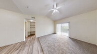 Located on Wurzbach Road in San Antonio, Texas, this one-bedroom, two-bathroom residence offers a thoughtfully laid-out single-floor plan with a welcoming sense of space. The living area immediately impresses with its dramatic vaulted ceiling and large sliding glass door framed by vertical blinds, flooding the room with natural light and providing views of the surrounding greenery. Durable hardwood-style flooring flows through the main living areas and kitchen, while plush carpet adds warmth to the bedroom spaces.

The galley-style kitchen is efficiently designed, featuring white cabinetry accented with warm wood trim, ample counter space, a stainless steel sink, and a full suite of white appliances including a refrigerator, electric range, microwave, and dishwasher. A charming arched entryway adds an architectural detail that enhances the kitchen's character.

The bedroom is a comfortable, carpeted retreat with a ceiling fan, natural light from a large window with outdoor views, and access to a dedicated closet. Both bathrooms are clean and functional — one features a wide vanity with warm wood cabinetry and a large mirror, while the other includes a tiled shower-tub combination. A hallway connects the rooms, completing this efficient and practical layout.