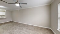 Located at 100 Alexander Xing in Loganville, Georgia, this two-story, 2-bedroom, 3-bathroom home offers a well-designed layout spread across two floors. The main level features an open-concept living, dining, and kitchen area with light wood-look flooring, crown molding, and a ceiling fan with built-in light fixture. The front entry opens directly into this bright, airy space with a staircase leading to the upper level. The kitchen is outfitted with white shaker-style cabinetry, a subway tile backsplash, stainless steel appliances including a refrigerator, range, microwave, and dishwasher, and a white quartz peninsula with an undermount sink — ideal for casual dining and entertaining. A dedicated laundry area and a full bathroom are also found on the main floor. Upstairs, the two bedrooms feature plush carpet flooring and vaulted or elevated ceilings, adding a sense of openness. Each bedroom includes closet space, and the primary bedroom offers a generous footprint with its own access to a full bathroom. Two additional bathrooms feature tub-shower combinations, white vanities, and wood-look tile floors. Crown molding and consistent neutral-toned walls carry throughout, creating a cohesive and clean aesthetic across the entire home.