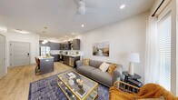 Located at 2136 Central Ave in Indianapolis, IN, this well-designed one-bedroom, one-bathroom unit offers a thoughtfully planned open-concept layout across a single floor. Light wood-tone flooring flows throughout, tying the living spaces together cohesively.

The living room is bright and airy, featuring a ceiling fan, recessed lighting, and French doors that invite natural light and provide outdoor access. The space comfortably accommodates a seating area and media setup.

The kitchen is a standout, outfitted with dark wood cabinetry, white quartz countertops, a full suite of stainless steel appliances — including a refrigerator, range, and microwave — and a peninsula island with bar seating and pendant lighting overhead. Open shelving adds a modern, functional touch.

The bedroom offers natural light through large windows with blinds and sheer curtains, a ceiling fan, and a walk-in closet with dual hanging rods and shelving for ample storage.

The bathroom features a glass-enclosed shower, a dark-cabineted vanity with a white countertop, and a clean, minimalist design consistent with the rest of the unit.

Recessed lighting and a neutral color palette throughout create a modern, welcoming ambiance well-suited to everyday living.