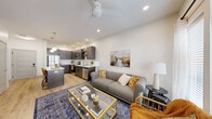 Located at 2136 Central Ave in Indianapolis, IN, this well-designed one-bedroom, one-bathroom unit offers a thoughtfully planned open-concept layout across a single floor. Light wood-tone flooring flows throughout, tying the living spaces together cohesively.

The living room is bright and airy, featuring a ceiling fan, recessed lighting, and French doors that invite natural light and provide outdoor access. The space comfortably accommodates a seating area and media setup.

The kitchen is a standout, outfitted with dark wood cabinetry, white quartz countertops, a full suite of stainless steel appliances — including a refrigerator, range, and microwave — and a peninsula island with bar seating and pendant lighting overhead. Open shelving adds a modern, functional touch.

The bedroom offers natural light through large windows with blinds and sheer curtains, a ceiling fan, and a walk-in closet with dual hanging rods and shelving for ample storage.

The bathroom features a glass-enclosed shower, a dark-cabineted vanity with a white countertop, and a clean, minimalist design consistent with the rest of the unit.

Recessed lighting and a neutral color palette throughout create a modern, welcoming ambiance well-suited to everyday living.