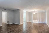 Located on Plaza Dr SE in Smyrna, Georgia, this single-floor residence offers a well-organized layout with a clean, neutral aesthetic throughout. The living areas feature warm hardwood-style flooring that extends from the entry foyer through the main living space, which is bathed in natural light through large windows fitted with horizontal blinds. A generous pendant light fixture anchors the living area, adding a welcoming touch.

The kitchen is thoughtfully updated with crisp white cabinetry, granite-style countertops, and a gray subway tile backsplash. Black appliances — including a refrigerator and dishwasher — provide a bold contrast against the bright cabinetry, while a large window brings in ample natural light, making the space feel open and functional.

Multiple bedrooms are finished with plush carpeting, neutral gray walls, and ceiling fans with integrated lighting, creating comfortable and versatile spaces. Each room benefits from natural light through windows, enhancing the overall airy atmosphere.

The bathroom is neatly appointed with a white tub-shower combo, a white vanity with a clean countertop, and wood-style flooring that ties the space together cohesively. Throughout the home, consistent neutral tones, white trim, and textured ceilings contribute to a cohesive and move-in-ready presentation.