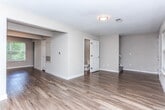 Located at 5100 Welcome All Rd SW in South Fulton, GA, this two-story residence offers a clean, modern aesthetic throughout its thoughtfully designed interior. Rich wood-look flooring runs through the main living areas, kitchen, and bathrooms, providing a cohesive and easy-to-maintain foundation across the home.

The kitchen is well-equipped with dark espresso cabinetry, granite-style countertops, and black appliances including a refrigerator, dishwasher, and electric range. A double-basin sink and ample cabinet storage complete this functional cooking space.

The living and dining areas are bright and open, benefiting from multiple windows that invite natural light and views of the surrounding greenery. A secondary entry door adds convenient access from this level.

Bedrooms offer a comfortable retreat, with plush carpeting, ceiling fans, and closet storage including dedicated built-in shelving. The layout provides a sense of privacy and ease of movement between spaces.

The bathrooms are finished with dark wood vanities, white countertops, and wood-look flooring. One bathroom features a full tub-shower combination, while another is appointed as a half bath. Chrome fixtures and wall-mounted towel bars add a polished touch throughout.

Overall, the space presents a neutral, move-in-ready palette with practical finishes suited for everyday living in the South Fulton community.