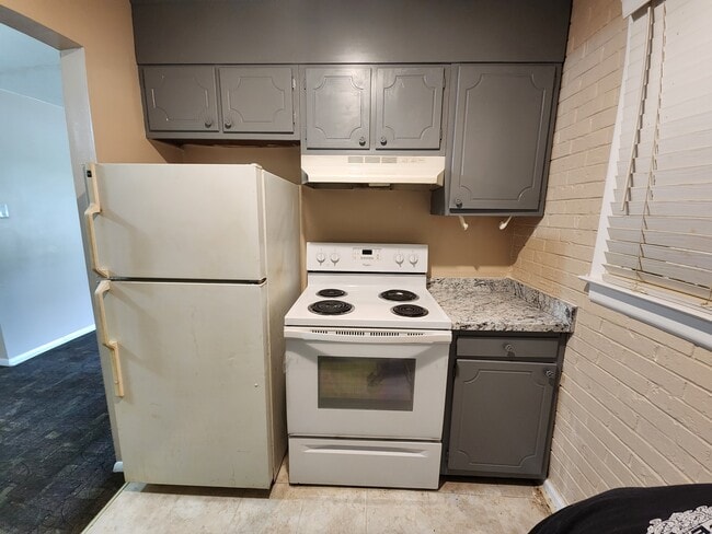 Cocina con estufa y refrigerador. - Emerald Commons