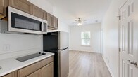 Located at 1023 Old Lascassas Rd in Murfreesboro, TN, this efficiently designed 2-bedroom, 1-bathroom unit offers a practical and modern living experience across a single floor. Light wood-style flooring runs throughout the space, creating a cohesive and clean aesthetic.

The kitchen is thoughtfully appointed with warm-toned cabinetry, white countertops, a stainless steel refrigerator, an over-the-range microwave, a smooth cooktop, and a single-basin sink — providing all essential cooking amenities in a compact, well-organized layout. The adjacent living area benefits from natural light streaming through a window and is topped with a ceiling fan for added comfort.

The primary bedroom is the larger of the two rooms, offering a comfortable footprint with a window that frames greenery outside, filling the space with natural light. The second bedroom mirrors the clean, simple design with its own window and bright white walls.

The bathroom features a full tub-shower combination with a curtain rod, a warm wood-toned vanity with a white countertop, and light wood-style flooring that ties seamlessly into the rest of the unit. The overall design is clean, modern, and functional, making this a well-suited space for those seeking straightforward, updated living in Murfreesboro.