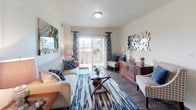This single-floor residence offers a thoughtfully designed layout that balances comfort and functionality across multiple well-defined living spaces. The living room serves as the heart of the unit, featuring wood-look flooring, a sliding glass door that opens to a private balcony with outdoor views, and ample space for stylish furniture arrangements. Natural light fills the room, creating a warm and inviting atmosphere.

The kitchen is equipped with warm-toned wood cabinetry, granite-style countertops, white appliances including a range, dishwasher, microwave, and refrigerator, and a peninsula that provides additional counter space and a casual eating option. Adjacent to the kitchen, the dining area accommodates a full dining set and includes a ceiling fan with light fixture.

The primary bedroom offers a serene retreat with carpeted flooring and generous space for a full bedroom suite. The secondary bedroom, also carpeted, includes a window with blinds and provides a comfortable, versatile space. The full bathroom features a vanity with granite-style countertops, wood-look tile flooring, and a shower-tub combination. A dedicated in-unit laundry room houses a full-size washer and dryer, adding everyday convenience to this well-rounded residence.