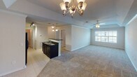 Located at 7205 Aventine Way in Chattanooga, Tennessee, this single-floor residence offers a thoughtfully designed layout that combines comfort and functionality. The open-concept living and dining area is anchored by plush wall-to-wall carpeting and is bathed in natural light from large windows dressed with blinds. A decorative chandelier and a ceiling fan with integrated lighting serve as complementary focal points overhead, while crown molding adds a refined architectural touch throughout.

The kitchen is a standout feature, showcasing rich dark cabinetry, gleaming granite countertops, a double stainless steel sink, and a full suite of black appliances including a refrigerator, range, and dishwasher. Track lighting and a pendant light illuminate the space, while tile flooring adds a clean, practical finish. A peninsula connects the kitchen to the main living area, creating a seamless flow ideal for entertaining.

The bedrooms are generously sized, each featuring soft carpeting, ceiling fans, and windows that invite natural light. The full bathroom includes a wide vanity with ample counter space, a tub-shower combination with tile surround, and tile flooring. A dedicated laundry room houses a full-size washer and dryer with additional shelving overhead, completing this well-appointed home.