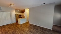 Located at 1519 Oswego Rd in Naperville, Illinois, this two-floor residence offers a well-designed layout that balances comfort and functionality throughout. The main living area features rich, dark hardwood-style flooring that flows seamlessly from the open living space into the kitchen, creating a cohesive and inviting atmosphere. Large windows allow ample natural light to fill the living areas, and a set of French doors opens to a private balcony overlooking lush greenery, providing a serene outdoor retreat.

The kitchen is thoughtfully appointed with white cabinetry, granite countertops, a peninsula with a double-basin sink, and a full suite of stainless steel appliances including a gas range, microwave, and refrigerator. Track lighting overhead adds both style and practicality to the space.

The bedrooms are carpeted for warmth and comfort, each offering generous proportions and ceiling fans for year-round convenience. Natural light filters in through windows fitted with blinds. The bathroom features a tiled tub-and-shower combination with a classic checkered accent tile border, complemented by hardwood-style flooring and clean white fixtures. Throughout the home, neutral tones and clean finishes create a bright, move-in-ready environment.