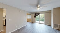 Located at 2601 Carpenter Station Rd in Wilmington, Delaware, this single-floor unit offers a thoughtfully designed layout with a cohesive blend of updated finishes and functional living spaces throughout.

The main living area is bright and open, featuring light gray wood-style flooring, neutral-toned walls, and a ceiling fan with light fixture. A sliding glass door opens to a private balcony with a wrought iron railing, offering pleasant views of surrounding greenery. The entry area includes built-in closet storage and connects seamlessly to the rest of the unit.

The kitchen has been updated with white shaker-style upper cabinets, contrasting gray lower cabinets, and marble-style countertops. Stainless steel appliances include a refrigerator, range with electric cooktop, dishwasher, and a wall-mounted range hood, all set over matching wood-style flooring.

The bedrooms vary in flooring, with some featuring plush carpet and others continuing the wood-style flooring. Each room includes windows with blinds that allow natural light and views of the surrounding landscape. The bathroom is clean and functional, featuring white subway tile in the shower/tub surround, a vanity, and wood-style flooring throughout.