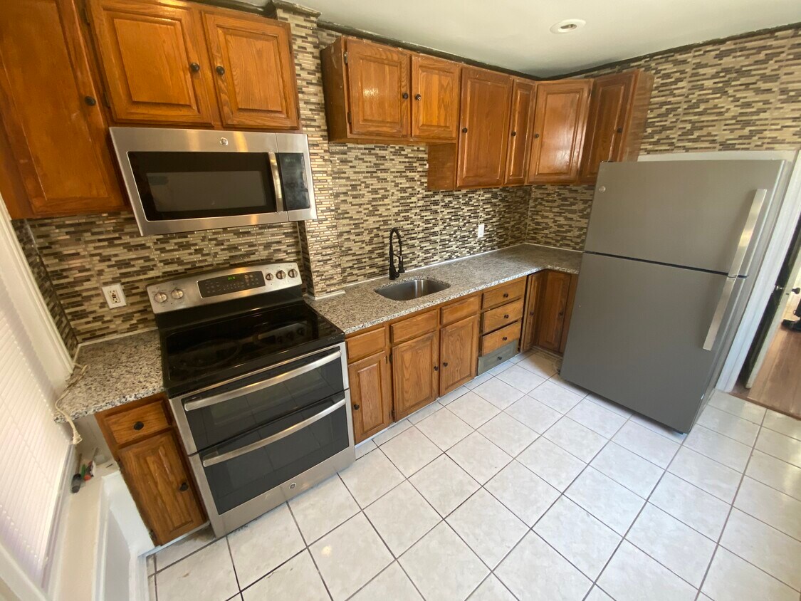 Kitchen - new granite countertop with a large stylish fridge - 433 N Fulton St
