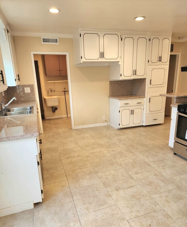 View of spacious kitchen cabinets and refrigerator area. - 7760 Lurline Ave