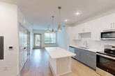 Located at 6735 Standifer Gap Rd in Chattanooga, TN, this thoughtfully designed one-bedroom, one-bathroom unit offers a well-organized, efficient layout across a single floor. The open-concept kitchen is a standout feature, showcasing two-tone cabinetry with crisp white upper cabinets and sophisticated gray lower cabinets, complemented by a classic white subway tile backsplash and gleaming quartz countertops. A central kitchen island provides additional workspace and visual appeal, while stainless steel appliances — including a refrigerator, range, microwave, and dishwasher — add a polished, modern touch. Pendant lighting with metallic accents illuminates the island and living area, enhancing the contemporary aesthetic. Light wood-style flooring runs throughout the main living spaces, contributing to a bright and airy atmosphere, aided by natural light from windows overlooking a green outdoor setting. The bedroom is carpeted for comfort, with a large window framing pleasant outdoor views and neutral walls offering a calm, restful retreat. A dedicated closet provides practical storage. The bathroom is clean and modern, featuring a glass-enclosed walk-in shower with marble-style tile surround, wood-tone flooring, and a gray vanity with a white countertop. The overall design is cohesive, contemporary, and move-in ready.