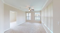 Located at 5960 Siegen Ln in Baton Rouge, Louisiana, this single-floor residence offers a well-organized layout with comfortable living spaces throughout. The spacious living room is highlighted by crown molding, a ceiling fan with light kit, and multiple large windows dressed with vertical blinds that allow generous natural light to fill the room. Plush wall-to-wall carpeting extends through the living area and into each bedroom, providing a warm and cohesive feel.

The bedrooms are generously proportioned, each featuring ceiling fans, neutral-toned walls, and large windows that offer views of the surrounding greenery. The layout provides a comfortable sense of openness in each room.

The kitchen is equipped with warm oak cabinetry, light-toned countertops, and black appliances including a range and over-the-range microwave. Wood-look flooring runs through the kitchen and connects to a dedicated laundry area nearby, adding practicality to the space.

The bathrooms feature oak cabinetry with ample storage, soaking tubs with shower combinations, and wood-look flooring that complements the warm tones found throughout the unit. A front entry door with sidelight windows welcomes natural light into the entryway, which opens directly into the broad living area. Overall, the space presents a clean, neutral palette well-suited for a variety of lifestyles.