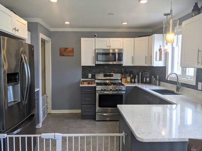 Beautiful updated kitched with quartz counters and breakfast bar - 4135 Park Ave