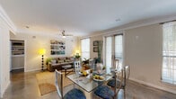 This well-appointed two-bedroom, two-bathroom residence in New Orleans offers a thoughtfully designed single-floor layout. Polished concrete floors run throughout much of the unit, lending a sleek, modern aesthetic that complements the neutral color palette. A welcoming entry hallway leads directly into the open-concept living and dining area, where crown molding, a ceiling fan, and large windows with blinds create a bright and comfortable atmosphere. The dining space accommodates a full-size glass table, while the adjacent living room provides ample room for relaxed seating and entertaining. The kitchen is equipped with light wood cabinetry, granite-style countertops, full appliances including a refrigerator, electric range, and built-in microwave, plus a convenient pantry closet. Both bedrooms are generously sized with ceiling fans and soft carpeting. The primary bedroom connects to a private bathroom featuring a glass-enclosed shower, while the second bathroom offers a full soaking tub and shower combination. Each bathroom includes vanity cabinetry and polished concrete flooring. A dedicated laundry room with side-by-side washer and dryer and overhead shelving adds everyday convenience. This residence combines practical functionality with a relaxed, contemporary feel suited to life in New Orleans.