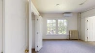 Located at 509 Wyckoff Rd in the charming village of Cayuga Heights, NY, this 2-bedroom, 1-bathroom unit offers a practical and comfortable single-floor layout. The space is finished throughout with soft carpet flooring and bright, neutral wall tones that contribute to a clean and welcoming atmosphere.

The spacious primary bedroom is generously sized and features large multi-pane windows that frame lush, leafy tree views, flooding the room with natural light. A wall-mounted mini-split air conditioning unit and a classic cast-iron radiator provide year-round climate control. An additional bedroom offers its own closet with a built-in rod and shelf for convenient storage.

The kitchen area is efficiently designed with white cabinetry, a double-basin sink, a white electric range, and an over-the-range microwave. Notably, an open double closet adjacent to the kitchen provides extra storage capacity. The unit includes a total of three closets throughout, ensuring ample organization options.

The bathroom is straightforward and functional, featuring tile flooring, a full tub-shower combination with a clean white surround, and a cast-iron radiator. The unit's layout, as seen in the dollhouse view, flows logically from the main living areas to the private spaces, making efficient use of the overall footprint.