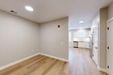 Located at 150 Draper Ave in North Attleborough, MA, Unit 202 is a well-appointed, single-floor unit that makes efficient use of its compact footprint. The interior is finished with warm-toned luxury vinyl plank flooring throughout, complemented by neutral gray walls and crisp white trim, creating a clean and modern aesthetic.

The open-concept kitchen and living area serves as the heart of the unit. The kitchen is outfitted with white shaker-style cabinetry extending to the ceiling, granite countertops, a subway tile backsplash, and a full suite of stainless steel appliances including a refrigerator, range, microwave, and dishwasher. Large windows in the kitchen and living area allow natural light to fill the space. Recessed lighting provides consistent illumination throughout.

The bathroom features a white vanity with matching granite countertops, a framed mirror, and grab bars, indicating accessibility-conscious design. Three closets offer ample storage, while a dedicated laundry area and a separate utility room add practical convenience. An electrical panel is accessible in the main hallway. The overall design is modern, clean, and functional, making this unit a well-organized living space.