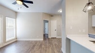Located at 2003 Skyline Dr in McKinney, TX, this one-bedroom, one-bathroom unit offers a smartly designed single-floor layout that maximizes every square foot. Rich wood-look flooring runs throughout the entire space, tying the rooms together with a warm, cohesive aesthetic.

The open-concept living area flows directly into the kitchen, which serves as the clear focal point of the unit. A peninsula with a crisp white quartz countertop and an undermount sink with a gold-finish faucet provides both prep space and a casual dining area. White shaker cabinets, a subway tile backsplash, and a full suite of stainless steel appliances — including a range, microwave, and refrigerator — give the kitchen a clean, contemporary feel. Two geometric pendant lights hang above the peninsula, adding a modern decorative touch.

The living area is anchored by a ceiling fan and features neutral gray walls that complement the flooring, creating a calm and versatile backdrop. The bedroom is a well-proportioned retreat with its own ceiling fan, a window that brings in natural light, and direct access to a dedicated closet with louvered bifold doors. The bathroom is finished with a full-size soaking tub and shower, a white vanity with a light countertop, and gold accent hardware throughout.