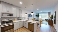 Located at 1220 South Ave in Plainfield, NJ, this well-appointed one-bedroom, one-bathroom residence offers a thoughtfully designed layout across a single floor. The open-concept kitchen and living area serves as the heart of the home, featuring light gray cabinetry, stainless steel appliances, a tiled backsplash, and a peninsula island with pendant lighting and bar seating — ideal for both cooking and entertaining. Warm hardwood-style flooring runs throughout, complementing the clean white walls and modern finishes. The living room is bright and inviting, with large windows that frame outdoor views and allow generous natural light to fill the space. A dedicated dining area adds to the functionality of the shared living space. The bedroom is comfortably sized, offering a window with outdoor views, and direct access to a well-organized closet. The bathroom features floor-to-ceiling tile, a soaking tub with shower, and matte black fixtures for a contemporary touch. A dedicated entryway with additional closet access and clean sightlines throughout completes this efficient and stylish residence. The overall ambiance is modern and welcoming, with a cohesive design aesthetic that balances comfort and function.
