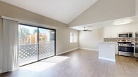 Located at 760 South Hill Road in Ventura, California, this 2-bedroom, 2-bathroom residence offers a well-designed single-level layout. The living room makes a strong first impression with soaring vaulted ceilings and durable hardwood-style flooring that flows throughout the main areas. A sliding glass door fills the space with natural light and opens to a private balcony with views of the surrounding neighborhood. The kitchen is thoughtfully appointed with white cabinetry, a mosaic tile backsplash, stone-look countertops, a peninsula breakfast bar, and a full suite of stainless steel appliances including a gas range, microwave, dishwasher, and refrigerator. Both bathrooms feature clean, bright tub-shower combinations with white surrounds and wood-look flooring. The spacious primary bedroom includes vaulted ceilings, a large window, and a dedicated closet with built-in shelving. The second bedroom is equally well-sized, offering plush carpeting and a window with natural light. Both bedrooms are finished with neutral carpet and soft wall tones, creating a calm, comfortable atmosphere throughout the home.