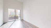Located at 801 Pearl Street in the desirable La Jolla neighborhood of San Diego, this thoughtfully designed one-bedroom, one-bathroom residence offers a clean, modern aesthetic throughout. Soaring ceilings create an impressive sense of openness and volume, while wood-look flooring runs continuously across the entire floor plan, adding warmth and cohesion.

The combined kitchen and living area serves as the heart of the home. The kitchen is well-appointed with white shaker cabinetry, a neutral tile backsplash, stainless steel appliances including a side-by-side refrigerator, range, microwave, and dishwasher, all complemented by light countertops. The living area benefits from dramatic ceiling height and a sliding glass door that opens directly to a private outdoor patio, flooding the space with natural light.

The bedroom is a comfortable and serene retreat, featuring tall ceilings, a sliding double-door closet, and a large window that invites natural light and outdoor views. The full bathroom is clean and functional, with a white vanity, tiled shower-tub combination, and matte black fixtures for a contemporary accent. A dedicated laundry area adds everyday convenience. The overall ambiance is bright, minimal, and move-in ready.