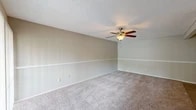 Located at 4500 Baymeadows Rd in Jacksonville, Florida, this single-floor residence offers four bedrooms and two bathrooms within a well-organized layout. The living room is a welcoming, open space finished with neutral-toned carpet, a textured ceiling, and a ceiling fan with light fixture. A sliding glass door floods the room with natural light and provides outdoor access, while a chair rail along the walls adds a subtle architectural detail.

The galley-style kitchen stands out with white shaker cabinetry, granite countertops, a stainless steel sink with a matte black faucet, and stainless steel appliances including a refrigerator and range. Light wood-look flooring completes the clean, modern aesthetic.

The four bedrooms are carpeted and finished with the same warm neutral tones found throughout the home. Several rooms feature ceiling fans and windows with blinds that allow natural light. The primary bedroom offers a generous footprint with ample wall space.

Both bathrooms are appointed with granite-topped vanities, white cabinetry, and tub-shower combinations, maintaining a consistent and updated finish. Light wood-look flooring ties the bathrooms together with the kitchen.

A dedicated closet and hallway contribute to the home's functional flow, making efficient use of the overall floor area across this single-level residence.
