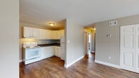 Located at 500 Fair St in Henderson, Kentucky, this single-floor residence offers a practical and well-maintained layout with consistent design elements throughout. Rich, dark hardwood-style flooring flows seamlessly across all living areas, creating a warm and cohesive aesthetic.

The kitchen is efficiently designed in an L-shaped configuration, outfitted with white cabinetry, dark countertops, and white appliances including an electric range, dishwasher, and refrigerator. An under-cabinet range hood and a stainless steel sink complete the functional workspace. The kitchen connects openly to the main living area, which offers generous space and a large closet with paneled double doors.

Multiple bedrooms are present, each finished with the same hardwood-style flooring and neutral taupe-toned walls. Windows dressed with white blinds allow natural light to filter in while offering views of the surrounding greenery. One bedroom features a spacious closet with sliding double doors and a separate entry door.

The bathroom is finished with light tile flooring and includes a full tub/shower combo with a white surround, a toilet, and a vanity with storage. Neutral wall tones carry throughout, contributing to a calm and cohesive interior. The open hallway connects all rooms efficiently, reinforcing the home's straightforward and functional single-floor design.