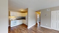 Located at 500 Fair St in Henderson, Kentucky, this single-floor residence offers a practical and well-maintained layout with consistent design elements throughout. Rich, dark hardwood-style flooring flows seamlessly across all living areas, creating a warm and cohesive aesthetic.

The kitchen is efficiently designed in an L-shaped configuration, outfitted with white cabinetry, dark countertops, and white appliances including an electric range, dishwasher, and refrigerator. An under-cabinet range hood and a stainless steel sink complete the functional workspace. The kitchen connects openly to the main living area, which offers generous space and a large closet with paneled double doors.

Multiple bedrooms are present, each finished with the same hardwood-style flooring and neutral taupe-toned walls. Windows dressed with white blinds allow natural light to filter in while offering views of the surrounding greenery. One bedroom features a spacious closet with sliding double doors and a separate entry door.

The bathroom is finished with light tile flooring and includes a full tub/shower combo with a white surround, a toilet, and a vanity with storage. Neutral wall tones carry throughout, contributing to a calm and cohesive interior. The open hallway connects all rooms efficiently, reinforcing the home's straightforward and functional single-floor design.