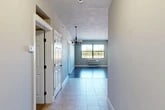 Located at 721 N Clinton St in Syracuse, NY, this single-floor residence offers a practical and comfortable layout with two bedrooms, two full bathrooms, and four closets. The entryway leads through a tiled hallway into an open living area illuminated by natural light from a large window and accented by an elegant chandelier, creating a welcoming atmosphere. The kitchen is well-appointed with rich warm-toned wood cabinetry, granite-style countertops, and a full suite of stainless steel appliances including a range, microwave, dishwasher, and refrigerator. Tile flooring and track lighting add a clean, functional finish to this space. The living area transitions seamlessly from the kitchen, featuring hardwood-style flooring and ample room for entertaining. Both bedrooms are carpeted for comfort, with neutral wall tones and generous closet access. The primary bedroom offers a comfortable footprint with direct access to the adjoining spaces. The two bathrooms are finished with tile flooring, wood vanities with granite-style countertops, and full tub-and-shower combinations. With four closets distributed throughout, storage is a practical highlight of this thoughtfully arranged residence.