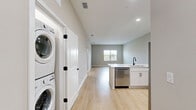 Located at 5790 Stockport St in Riverview, FL, this well-appointed 2-bedroom, 2-bathroom residence offers a thoughtfully designed single-level layout with a clean, modern aesthetic. Light wood-tone flooring flows seamlessly throughout the entire unit, creating a bright and cohesive atmosphere.

The open-concept kitchen and living area serves as the heart of the home. The kitchen is equipped with white shaker-style cabinetry, white quartz countertops, stainless steel appliances including a gas range, built-in microwave, and refrigerator, as well as a peninsula with an undermount sink — ideal for both cooking and casual dining.

The spacious primary bedroom features an en-suite bathroom with a walk-in glass-enclosed shower, a white vanity with quartz countertop, and matte black hardware accents. The second bedroom is generously sized, with a large window that invites natural light and offers views of the surrounding greenery. Both bedrooms include ceiling fans for year-round comfort.

The second bathroom is equally well-finished, featuring a full tub-shower combo, a white vanity, and consistent matte black fixtures. Neutral warm-gray walls throughout the unit complement the light flooring, lending the space a calm, contemporary feel. A connecting hallway ties all rooms together efficiently.