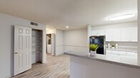 Located at Village Center Blvd in Fairburn, GA, this single-story, one-bedroom, one-bathroom residence offers a thoughtfully designed layout that maximizes comfort and functionality. The kitchen is a standout feature, showcasing white cabinetry, granite-style countertops, a tile backsplash, and black appliances including a refrigerator, electric range, and dishwasher. A peninsula counter extends the workspace and creates a natural divide between the kitchen and the living area, which features light wood-style flooring throughout. Convenient in-unit laundry and a large open shelving closet are tucked just off the main living space, adding practical storage and everyday ease. The generously sized bedroom is carpeted for warmth and comfort, featuring dual windows that invite natural light and outdoor views, complemented by a ceiling fan for year-round comfort. The full bathroom is clean and bright, with wood-style flooring, a single vanity with ample counter space, a toilet, and a full soaking tub with shower. Neutral tones and consistent finishes throughout the space create a cohesive, move-in-ready atmosphere suited for comfortable everyday living.