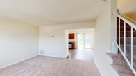 Located at 6520 Bricktown Cir in Glen Burnie, Maryland, this two-floor residence offers a thoughtfully designed layout with a neutral color palette and a blend of carpet and hardwood-style flooring throughout. The main level begins with a welcoming entryway featuring a classic wood-paneled front door and a large window that fills the space with natural light. The adjoining living area is generously proportioned with plush carpeting and flows seamlessly into a dining area with hardwood-style flooring. The kitchen is well-appointed with rich cherry-toned cabinetry, granite-look countertops, and a full suite of stainless steel appliances, including a refrigerator, electric range, microwave, and dishwasher. A sliding glass door off the kitchen area provides access to the outdoors and allows abundant natural light to permeate the space. The upper floor hosts multiple carpeted bedrooms, each featuring windows that provide natural light and outdoor views. One generously sized bedroom features dual windows, enhancing its bright and airy feel. The bathroom includes a tiled tub-shower combination, a vanity with a white countertop, and tile flooring, completing this functional and comfortable home.