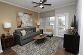 This thoughtfully designed 1-bedroom, 1-bathroom residence offers a cohesive blend of modern finishes and comfortable living across a single floor. The open-concept layout connects the living, dining, and kitchen areas seamlessly, creating an efficient and inviting flow throughout the space.

The kitchen is a standout feature, showcasing rich dark cabinetry, granite countertops, stainless steel appliances, and a large island with bar seating — ideal for casual dining or entertaining. Pendant lighting and track fixtures illuminate the workspace, while wood-style flooring extends throughout the main living areas, adding warmth and continuity.

The living room is bright and welcoming, with crown molding, a ceiling fan, and large windows that allow natural light to fill the room. A private exterior door leads to an outdoor area, enhancing the sense of openness.

The bedroom is a comfortable retreat, featuring plush carpeting, a warm accent wall, and a window that brings in additional natural light. The full bathroom connects conveniently to the bedroom and offers dark wood cabinetry, a granite vanity, and wood-style flooring. A closet with louvered doors provides practical storage. The overall ambiance throughout the residence is modern yet cozy, with neutral tones and warm accent colors creating a welcoming atmosphere.