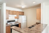 Located at 2124 University Ave in Madison, WI, this two-story, 4-bedroom, 2-bathroom unit offers a practical and well-organized layout spread evenly across two floors. The main level features an open kitchen and living area, where warm oak cabinetry, dark granite-style countertops, a double stainless steel sink, and wood-look flooring give the kitchen a functional, inviting character. A peninsula counter connects the kitchen to the carpeted living room, which is brightened by a large window and accented with a pendant light fixture. Both bathrooms are clean and simply appointed — one features a tub/shower combo with hardwood-style flooring, while the second includes a wide vanity mirror with overhead lighting, wood cabinetry, and a tub/shower unit. The four bedrooms are carpeted and neutral in tone, each offering generous windows that bring in natural light along with individual wall-unit climate control. Several bedrooms include dedicated closets with built-in shelving and hanging rods, providing strong storage capacity. A walk-in closet with multi-tier wooden shelving adds additional organization options. The staircase connects both floors seamlessly, and a hallway ties the upper-level rooms together efficiently. This unit is ideally situated near the University of Wisconsin–Madison campus.