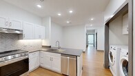 This single-floor, 3-bedroom, 2-bathroom home in Olathe, Kansas offers a clean, modern design throughout. The kitchen is a standout feature, equipped with white shaker-style cabinetry, dark countertops, a herringbone tile backsplash, and a full suite of stainless steel appliances including a gas range, dishwasher, and French door refrigerator. Light wood-style flooring flows through the kitchen and main living areas, complemented by recessed lighting overhead. The bedrooms are carpeted and feature ceiling fans and large windows with blinds that invite natural light, creating a comfortable and airy atmosphere. The primary bedroom offers a generous footprint with ample space for furnishings. Both bathrooms are finished with large-format marble-look tile on the floors and walls, each featuring a soaking tub with a sliding glass shower door and brushed nickel or matte black fixtures. A dedicated in-unit laundry area accommodates a side-by-side washer and dryer with overhead cabinetry for added storage. Hallways connect the rooms efficiently, and a door provides direct exterior access from one of the living areas. The unit presents a fresh, neutral palette throughout, suitable for a variety of living arrangements.