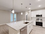 Located at 816 Addicks Howell Rd in Houston, TX, this thoughtfully designed single-story residence offers 2 bedrooms and 2 bathrooms within a comfortable and efficiently utilized floor plan. The open-concept kitchen serves as the heart of the home, showcasing granite countertops, a large center island with an undermount sink and pendant lighting overhead, crisp white shaker cabinetry, a classic subway tile backsplash, and a full suite of stainless steel appliances. The kitchen flows seamlessly into the combined dining and living area, which features light wood-look flooring, a ceiling fan, and French doors that open to a private covered balcony. The primary bedroom is generously sized, finished with plush carpeting and a ceiling fan, and connects directly to an en-suite bathroom and a walk-in closet with built-in shelving. The second bedroom also features carpet flooring, a ceiling fan, and natural light from dual windows. Both bathrooms are finished with granite vanity countertops and wood-look tile flooring, with one featuring a full soaking tub. Additional conveniences include a dedicated laundry area, a pantry, and ample closet storage throughout.