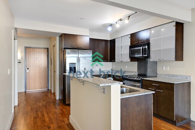 Building Photo - Top-Floor 1-Bedroom + Den with Space Needle Views & Exceptional Building Amenities
