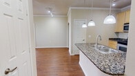 Located at 5202 Auburn St in Lubbock, Texas, this single-story, one-bedroom, one-bathroom unit offers a thoughtfully designed layout that maximizes its comfortable footprint. The open-concept living room and kitchen area serves as the heart of the home, featuring warm hardwood-style flooring, crown molding, and a ceiling fan with light fixture. Natural light streams in through multiple windows dressed with blinds, creating a bright and inviting atmosphere. The front entry door, also fitted with a window, adds to the sense of openness.

The kitchen is a standout feature, boasting granite countertops, light wood cabinetry, and a full suite of stainless steel appliances including a refrigerator, electric range, and built-in microwave. A peninsula with pendant lighting and a sink provides additional prep space and casual seating opportunities.

The bedroom is a well-sized retreat finished with plush carpeting, a ceiling fan, and a window for natural light. It connects directly to the full bathroom, which features tile flooring, a granite-topped vanity with light wood cabinetry, a large mirror, and a bathtub. A dedicated closet and hallway complete the efficient, functional floor plan.