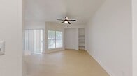Located in Austin, TX 78736, this thoughtfully designed one-bedroom, three-bathroom residence offers a clean, modern aesthetic throughout. Light wood-style flooring flows seamlessly across the single-floor layout, complementing the crisp white walls and crown molding found in the open living area. A ceiling fan with integrated lighting anchors the bright living space, which benefits from generous natural light through a sliding glass door with vertical blinds and an adjacent window offering leafy outdoor views. Built-in open shelving adds a functional architectural detail to the living room corner.

The kitchen is well-appointed with white shaker-style cabinetry accented by matte black hardware, a classic subway tile backsplash, white quartz countertops, and a full suite of stainless steel appliances including a refrigerator, range, dishwasher, and microwave. A peninsula with a undermount sink provides additional prep space and casual dining potential.

The bedroom is a calm, light-filled retreat with a large window framing greenery outside. The bathrooms are elegantly finished, highlighted by a soaking tub surrounded by marble-look tile, matte black fixtures, and a vanity featuring a framed mirror with contemporary lighting — delivering a polished, cohesive feel throughout.