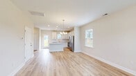 Located at 304 Bedstone Dr in Navassa, NC, this well-appointed two-story home offers a thoughtful layout across two floors. The main level features a bright, open-concept living, dining, and kitchen area bathed in natural light from multiple windows. The kitchen is a standout, showcasing white shaker cabinetry, a subway tile backsplash, light granite countertops, a center island, stainless steel appliances, and recessed lighting. Light wood-tone luxury vinyl plank flooring flows seamlessly throughout both levels, complementing the home's clean, neutral palette. An elegant chandelier anchors both the dining area and the entryway, adding a refined touch. The main floor also includes an attached garage with an automatic opener and an electrical panel. Upstairs, three well-sized bedrooms provide comfortable retreats, including a spacious primary bedroom with a walk-in closet featuring wire shelving. The primary bathroom is equipped with a dual-sink vanity, white cabinetry, and a glass-enclosed shower. Additional bathrooms include a tub-shower combo. Each bedroom features its own closet, and a dedicated laundry area adds everyday convenience. The exterior showcases a fully fenced backyard, offering ample outdoor space and privacy.