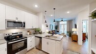 Located at 760 Airport Blvd in Austin, TX, this one-bedroom, one-bathroom unit offers a smart, efficient layout that maximizes every inch of its single-floor footprint. The open-concept design seamlessly connects the kitchen and living room, creating an airy, cohesive living space bathed in natural light.

The kitchen is outfitted with crisp white shaker cabinetry, quartz-style countertops, a subway tile backsplash, and a full suite of stainless steel appliances including a refrigerator, range, microwave, and dishwasher. A peninsula with a undermount sink and sleek black pendant lighting anchors the space and provides additional prep and casual dining areas.

The living room features light wood-tone flooring, a ceiling fan, and French doors that open to an outdoor area, filling the room with natural light and providing a welcoming sense of openness. Built-in shelving near the entry creates a practical and stylish mudroom-style nook with hooks and storage cubbies.

The bedroom is a comfortable retreat with large windows, a ceiling fan, and generous natural light. The adjacent bathroom is clean and functional, featuring a soaking tub with shower, light tile flooring, and direct access to a dedicated walk-in closet. Throughout, the design maintains a cohesive modern aesthetic with white walls, black hardware accents, and warm wood flooring.